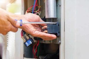 Close up of repairman installing magnetic contactor and fixing HVAC system