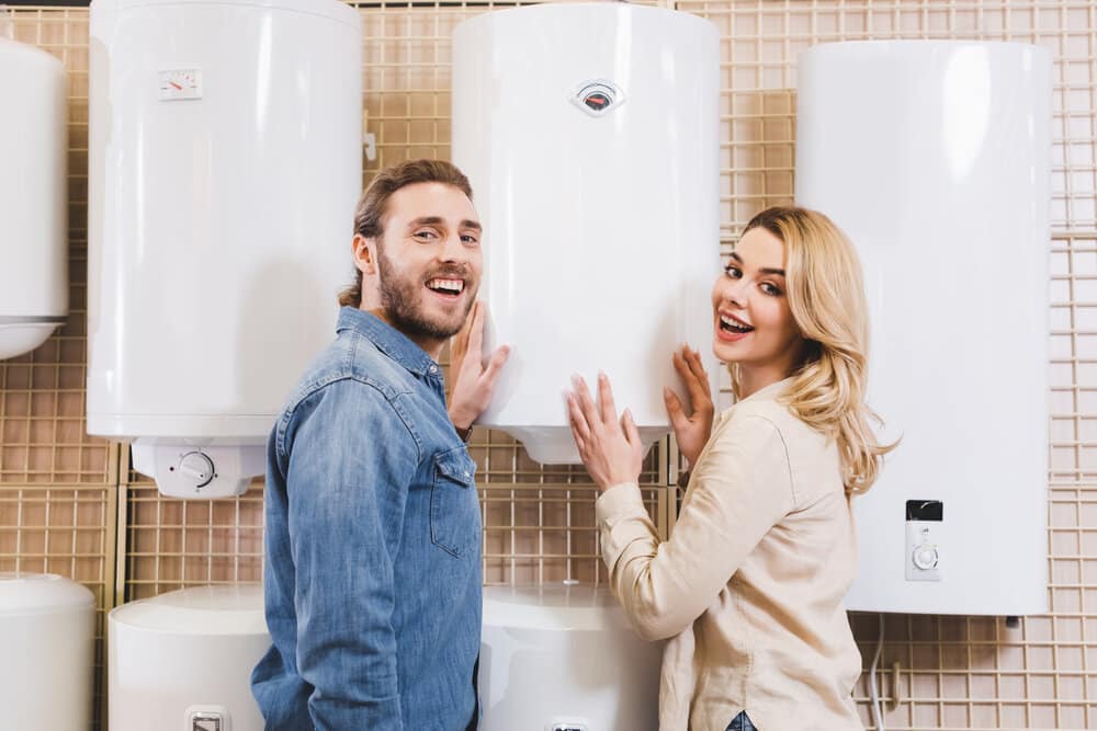 smiling boyfriend and girlfriend deciding between hot water heater or boiler in home appliance store